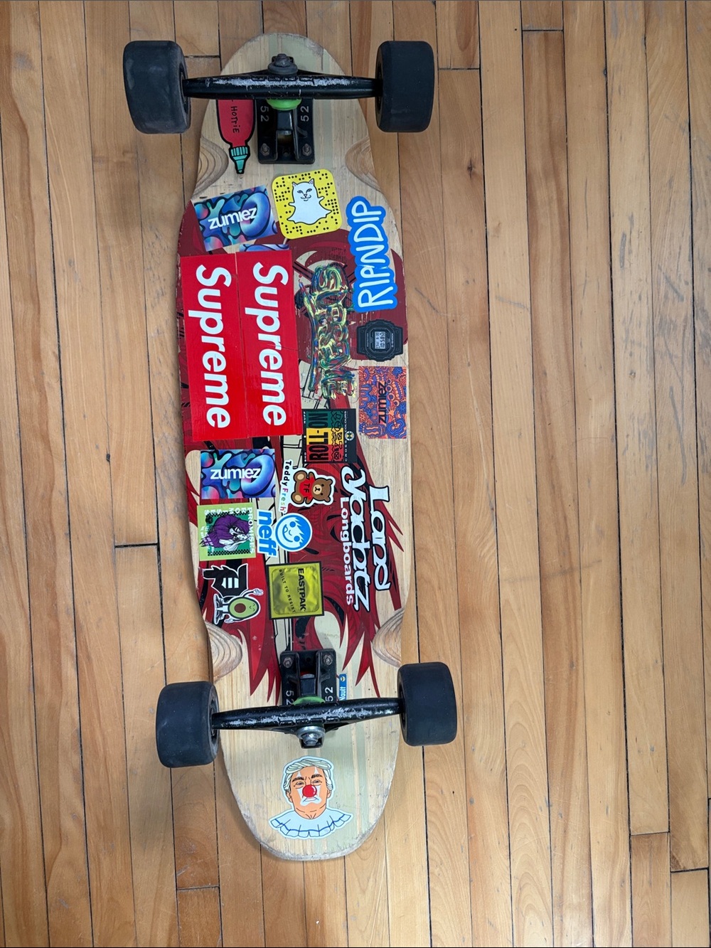 Ladyachts Sticker bombed longboard with Supreme Sticker